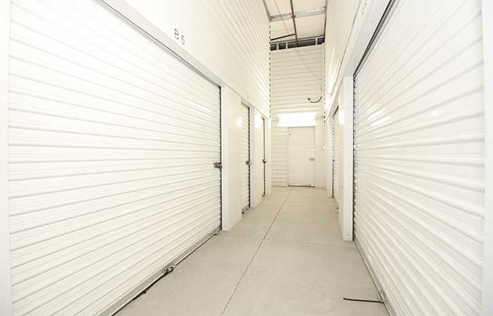Large indoor climate controlled storage units in a well-lit hallway.