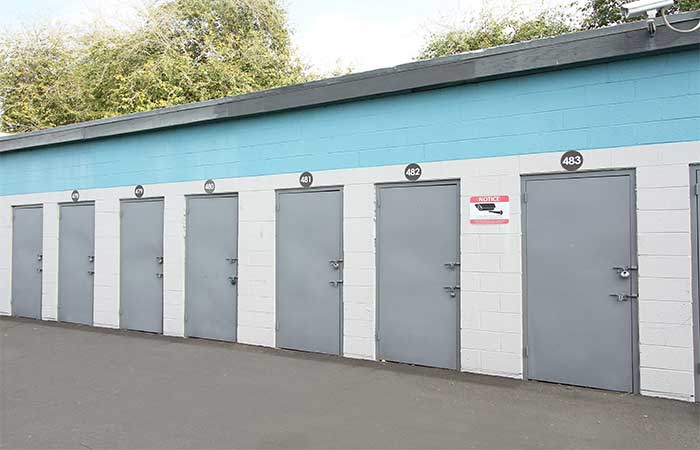 Small drive-up storage units with swing doors.