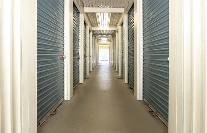Small storage units located in a well-lit breezeway.