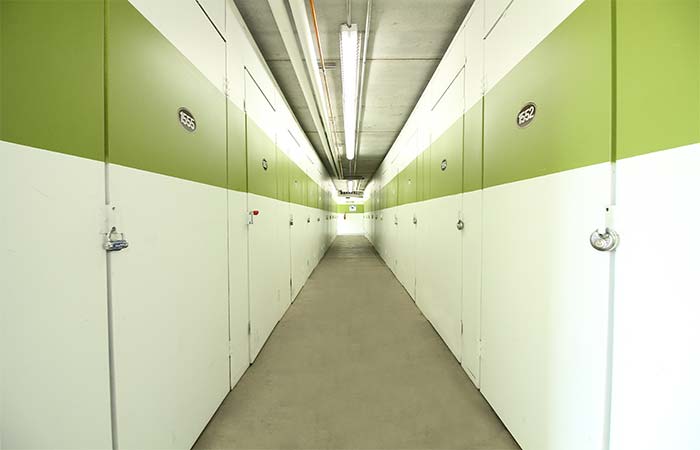 Small indoor storage units in a long hallway.