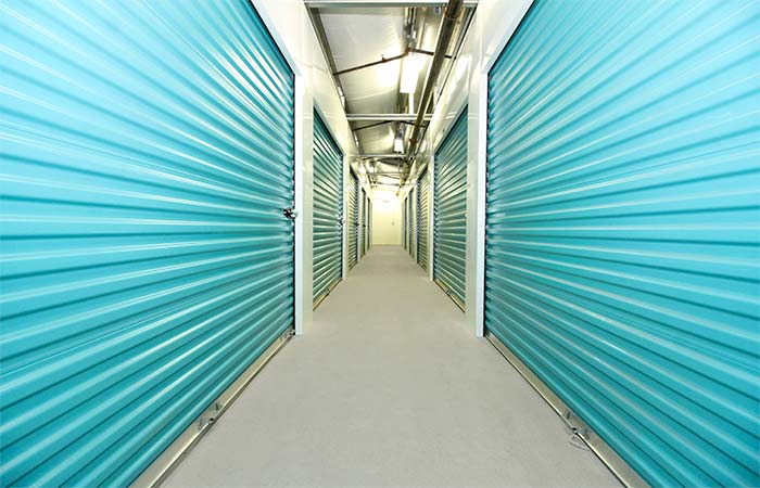 Well-lit indoor storage unit hallway.