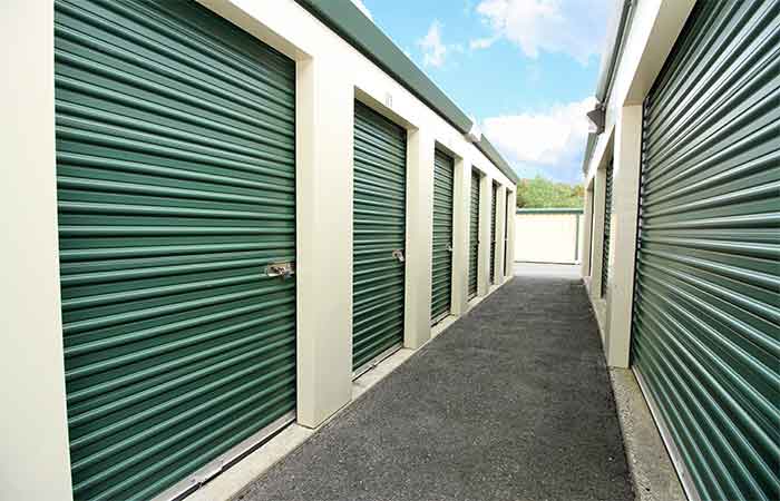 Small breezeway storage units with roll-up doors.