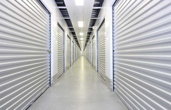 Well-lit, climate controlled storage unit hallway.