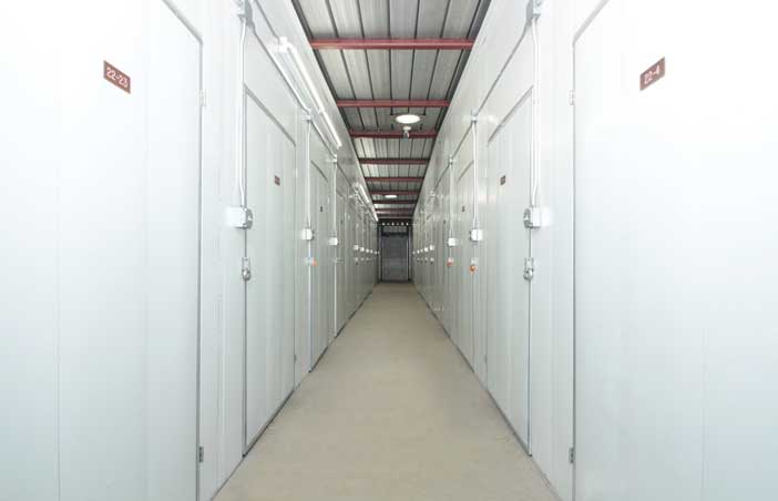 Well-lit indoor hallway with small storage units.