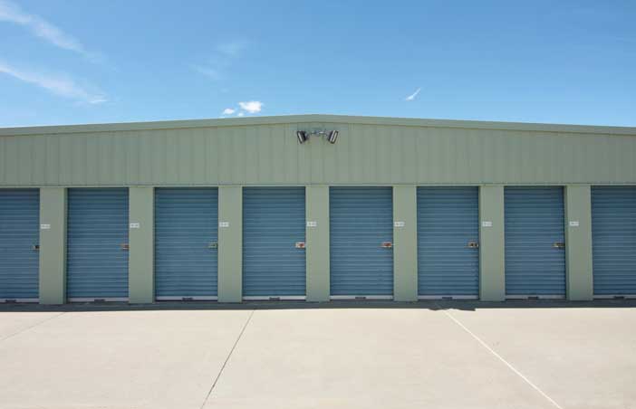 Small drive-up storage units with easy access and roll-up doors.