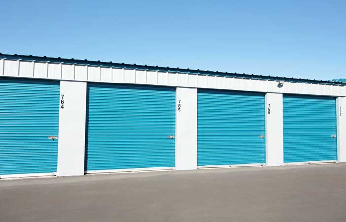 Large drive-up storage units with roll-up doors.