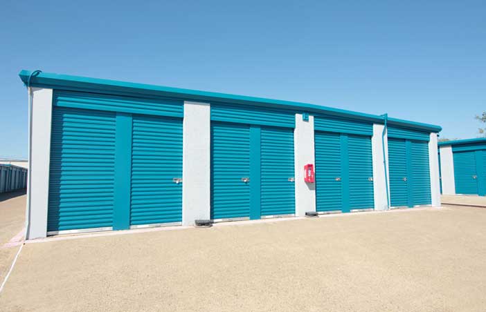 Small drive-up storage units with roll-up doors.