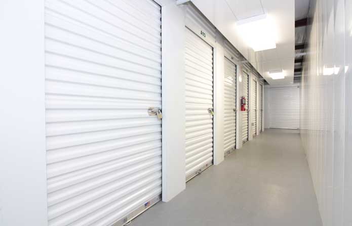 Small climate controlled storage units in a well-lit hallway.