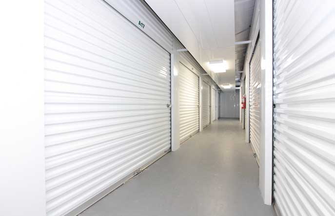 Well-lit indoor climate controlled storage unit hallway.